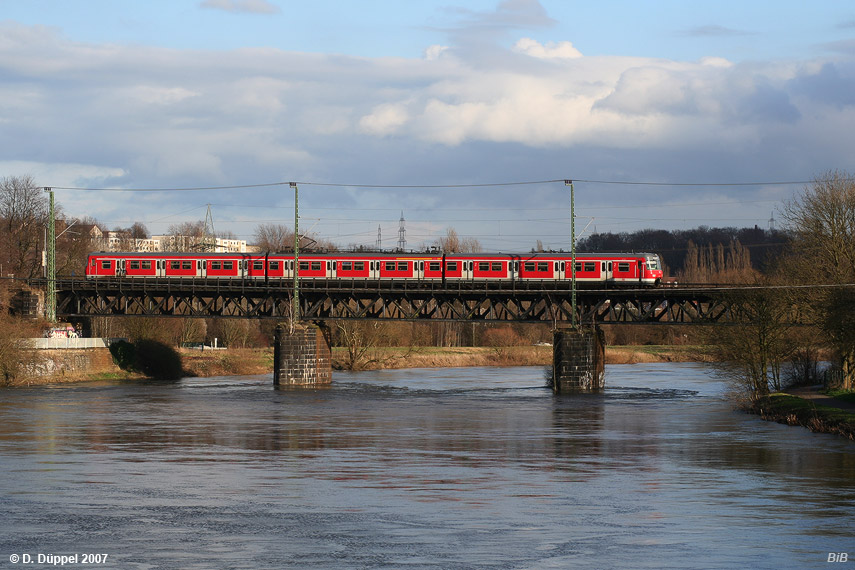 0703-44: Ein Richtung Wuppertal fahrender S-Bahnzug berquert die Ruhr bei Essen-Steele.