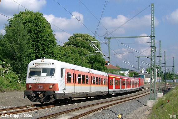 0405-08: Im Mai 2004 sind auch die S-Bahnsteuerwagen in oranger Ausfhrung rah geworden. Nachdem die 143er schon lange verkehrsrot wurden gab es zu diesem Zeitpunkt nur noch einige wenige Garnituren die komplett in den alten S-Bahnfarben fuhren. Auch dieser orange/weier Steuerwagen war ein Glckstreffer. Hier befhrt eine S 9 gerade die Senke vor dem Hp Essen-Kupferdreh.