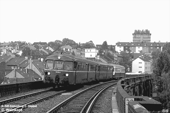 0408-71: Der Begriff Stadtbahn charakterisiert dieses Bild ganz gut: Auf einem der zahlreichen Viadukte schlngelt sich der Rheinische Bahn durch den Norden Wuppertals. Hier ist ein Zug kurz vor Wichlinghausen vor dem Hintergrund der dichten Bebauung und eines Hochbunkers abgebildet.