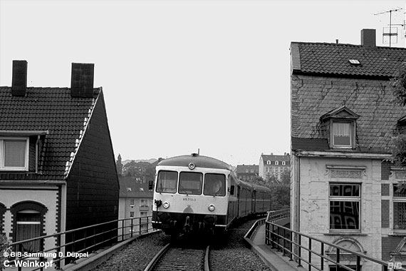 0408-74: Wie eng der Kontakt zwischen Bahn und Bebauung an der Nordbahn war, zeigt dieses Bild. Ein Triebzug befindet sich auf der Fahrt Richtung W-Oberbarmen und befindet such auf einem Viadukt der Verbindungskurve Wichlinghausen - Oberbarmen, als im Rahmen eines Fotothaltes dieses Bild entstand.