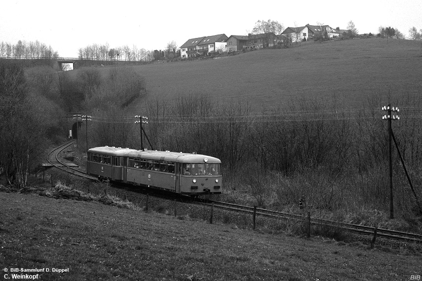 0410-34: Bei trbem Frhjahreswetter verlt eine Schienebusgarnitur den Meinerzhuser Tunnel.