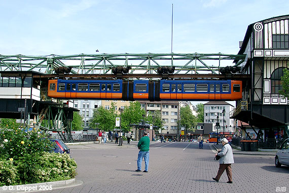 0505-37: Unsere Reise mit der Schwebebahn beginnt in Wuppertal-Oberbarmen, genau gegenber dem gleichnamigen Bahnhof und unweit des Busknotenpuntes am Berliner Platz. <BR>
Ein Zug aus Vohwinkel kommend hat soeben seine Fahrgste aussteigen lassen und fhrt nun in langsamer Geschwindigkeit in die Wagen- und Wendehalle Oberbarmen ein.