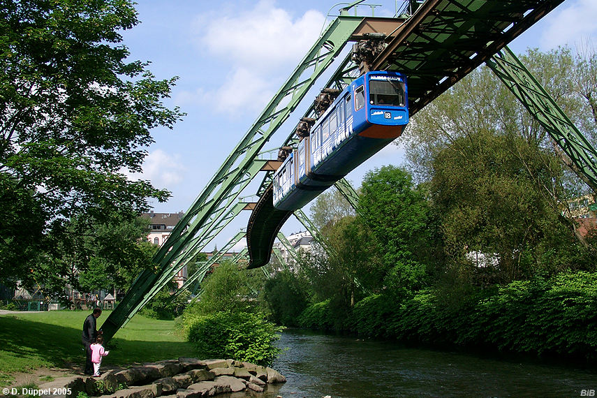 0506-53: Fr viele Wuppertaler Brger ist die Schwebebahn etwas selbstverstndliches. Sie schauen schon lngst nicht mehr nach oben, wenn eine Bahn ber ihre Kpfe hinwegfhrt. Auch das Mdchen mit ihrem Vater interessiert sich mehr fr die Wupper und die etwas natrlicher gestaltete Flachwasserzone.