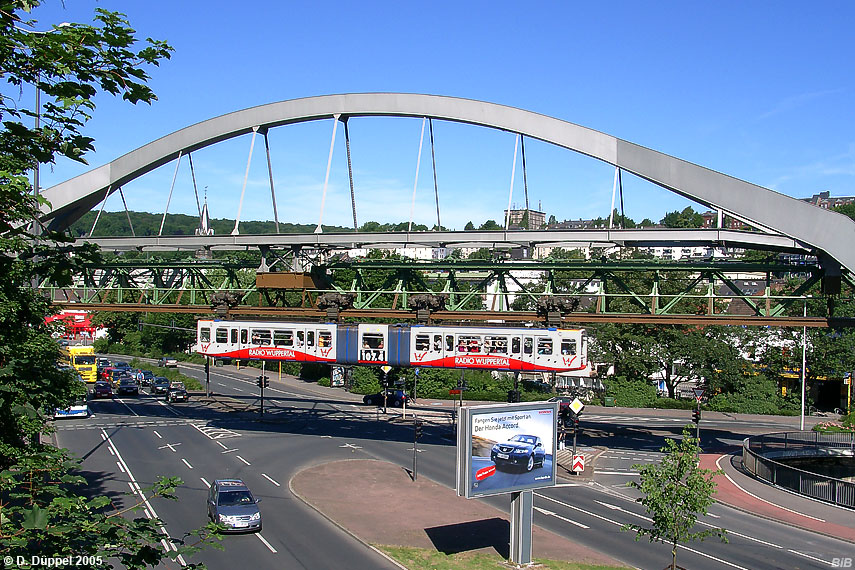 0506-65: Schwebebahnzug 20, mit Vollwerbung fr ein Wuppertaler Lokalradio, berquert die Bundesstrae 7 an der Ohligsmhle.