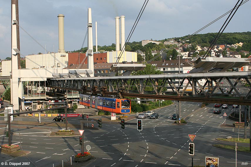 0706-74: Der Verkehrsknoten Alter Markt wurde Ende der 1960er Jahre vllig umgestaltet. Heute trifft eine Nord-Sd-Strassenverbindung auf die B 7, die in Tallngsrichtung verluft. Die Kreuzung befindet sich direkt ber der Wupper. Somit wird die Schwebebahn mit Hilfe eines langen Tragwerkes ber die stark frequentierte Kreuzung gefhrt. <BR> Das lngere, sttzenlose Streckenstck ber der Strasse besteht aus einer speziellen Brcke, die durch Schrgseile von vier Pylonen ausgehend gehalten wird. Der Bahnhof Alter Markt dient am stlichen Ende der Konstruktion als Kontergewicht.